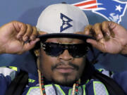 Seattle Seahawks' Marshawn Lynch adjusts his cap during an interview Thursday, Jan. 29, 2015, in Phoenix.