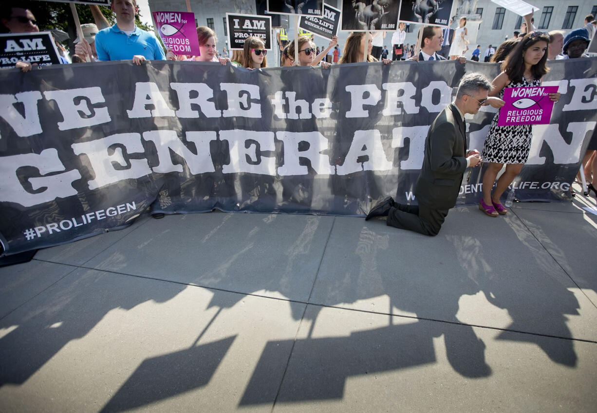 Michael Hichborn kneels and prays as he joins demonstrators while waiting for the Supreme Courtu2019s decision on the Hobby Lobby case outside the Supreme Court in Washington on Monday.