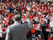 Washington Gov. Jay Inslee waves as he speaks to teachers and other education supporters during a Washington Education Association last month at the Capitol in Olympia.