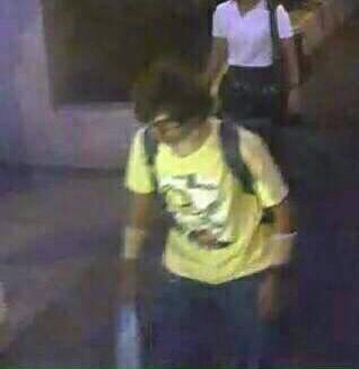 Aa man wearing a yellow T-shirt near the Erawan Shrine before an explosion occurred in Bangkok, Thailand.