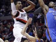 Portland Trail Blazers forward LaMarcus Aldridge, left, drives to the basket against Oklahoma City Thunder center Serge Ibaka, right, and Thunder forward Nick Collison during the second half Friday. Aldridge scored 29 points and pulled in 16 rebounds as the Blazers beat the Thunder 115-112.