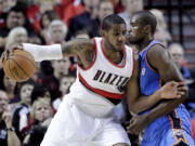 Portland Trail Blazers forward LaMarcus Aldridge, left, works the ball in on Oklahoma City Thunder center Serge Ibaka, from Congo, during the first half of an NBA basketball game in Portland, Ore., Wednesday, Oct.