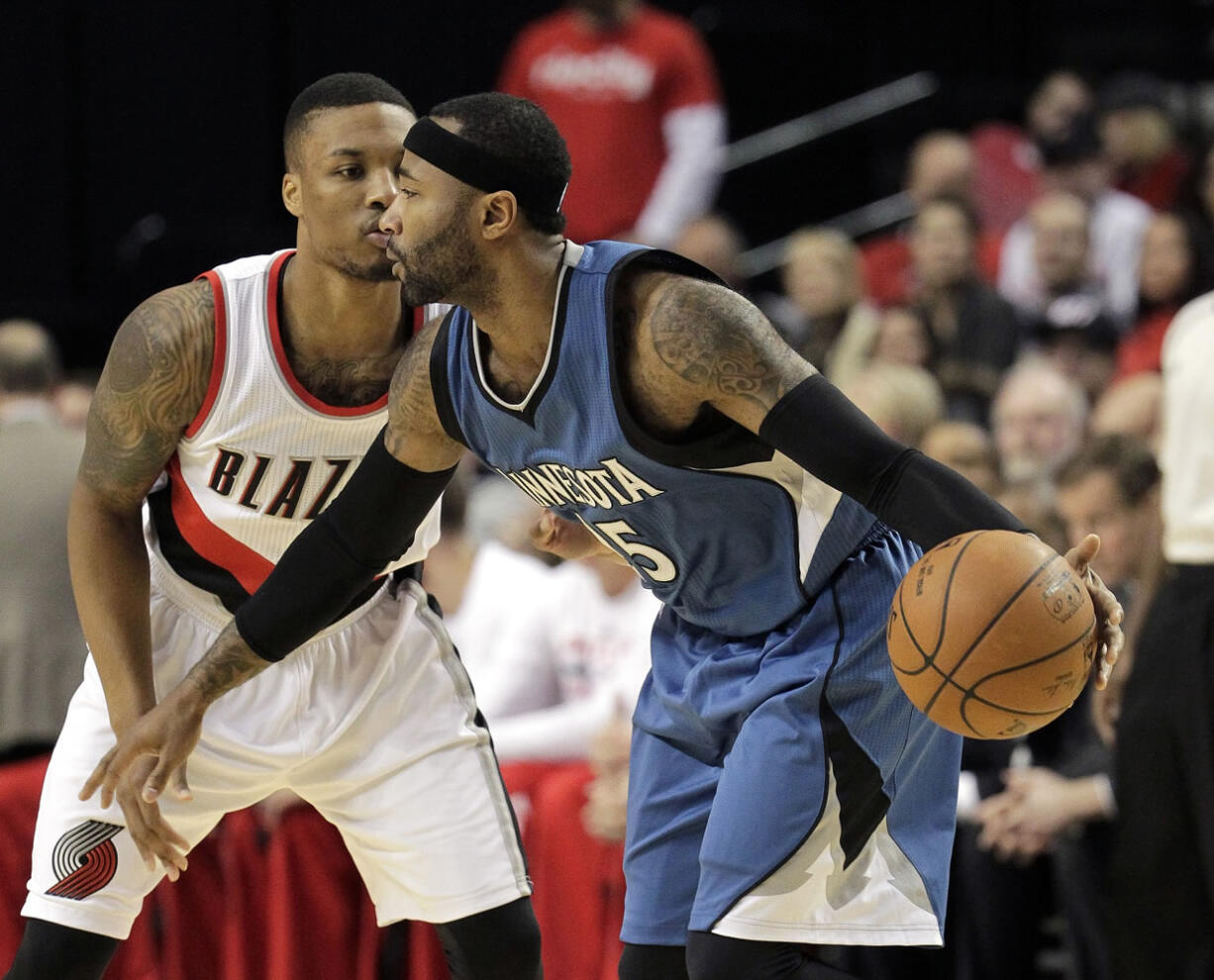 Minnesota Timberwolves guard Mo Williams, right, drives on Portland Trail Blazers guard Damian Lillard during the first half of an NBA basketball game  in Portland, Ore., Sunday, Nov. 30, 2014.