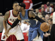 Minnesota Timberwolves guard Mo Williams, right, drives on Portland Trail Blazers guard Damian Lillard during the first half of an NBA basketball game  in Portland, Ore., Sunday, Nov. 30, 2014.