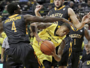 Oregon's Joseph Young, center, looks for a way past Toledo's Justin Drummond, left, and Nathan Boothe, right, during the first half in Eugene, Ore., Friday, Nov. 21, 2014.