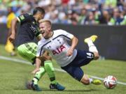 Tottenham Hotspur's Lewis Holtby (14) is tackled by Seattle Sounders' DeAndre Yedlin during the first half of a soccer match Saturday in Seattle.