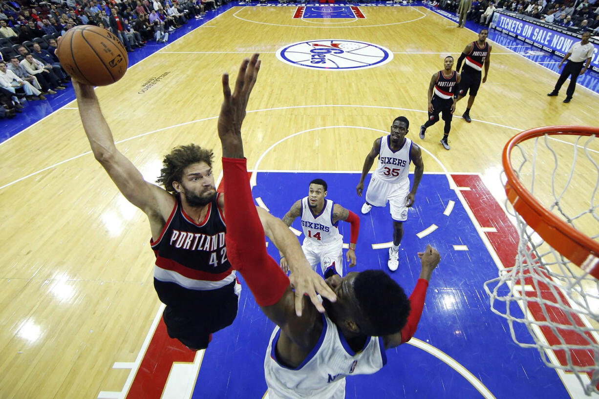 Portland Trail Blazers' Robin Lopez, left, goes up for a dunk against Philadelphia 76ers' Nerlens Noel during the first half of an NBA basketball game, Monday, Nov. 24, 2014, in Philadelphia.