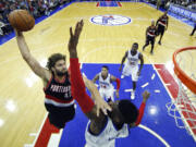 Portland Trail Blazers' Robin Lopez, left, goes up for a dunk against Philadelphia 76ers' Nerlens Noel during the first half of an NBA basketball game, Monday, Nov. 24, 2014, in Philadelphia.