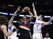 Portland Trail Blazers' LaMarcus Aldridge, center, goes up for a basket as he is defended by Los Angeles Clippers' DeAndre Jordan, left, and J.J. Redick during the second half of an NBA basketball game, Wednesday, March 4, 2015, in Los Angeles. The Trail Blazers won 98-93 in overtime. (AP Photo/Jae C.