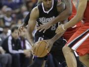 Portland's LaMarcus Aldridge, center, and Nic Batum double-team Sacramento's Rudy Gay on Friday.