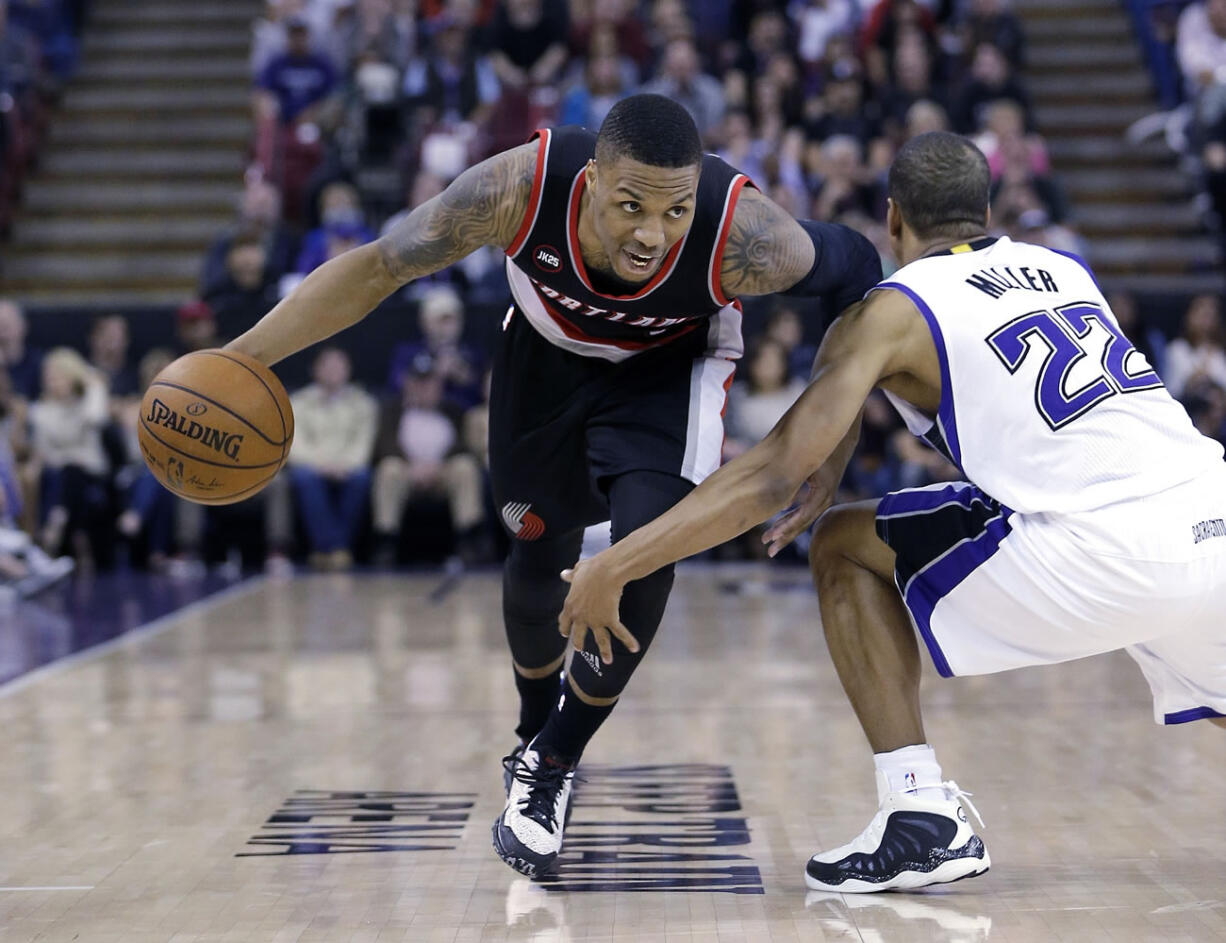 Portland Trail Blazers guard Damian Lillard, left, eludes Sacramento Kings guard Andre Miller as he drives to the basket during the second half at Sacramento, Calif., on March 1.