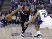 Portland Trail Blazers guard Damian Lillard, left, eludes Sacramento Kings guard Andre Miller as he drives to the basket during the second half at Sacramento, Calif., on March 1.