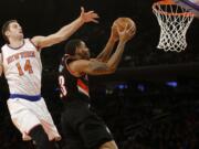 Portland's Allen Crabbe (23) drives past New York's Jason Smith (14) during the first half Sunday, Dec. 7, 2014, in New York.