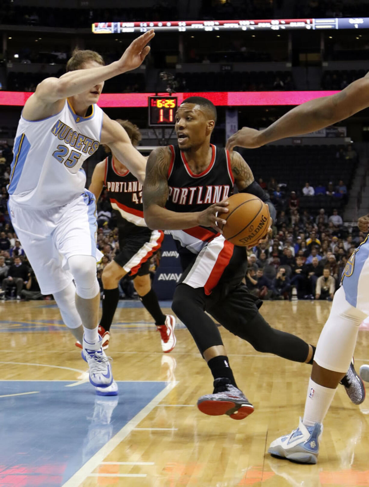 Portland Trail Blazers guard Damian Lillard drives past Denver Nuggets center Timofey Mozgov (25) during the first half Wednesday, Nov. 12, 2014, in Denver.