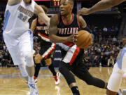 Portland Trail Blazers guard Damian Lillard drives past Denver Nuggets center Timofey Mozgov (25) during the first half Wednesday, Nov. 12, 2014, in Denver.