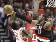 Portland Trail Blazers' LaMarcus Aldridge (12) knocks the ball away from Houston Rockets' James Harden (13) in the first half Sunday, Feb. 8, 2015, in Houston.