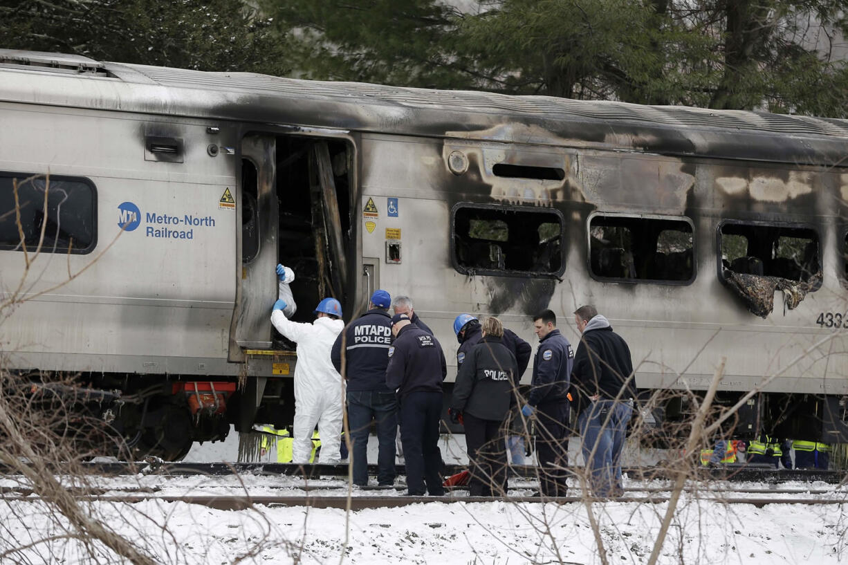 Emergency personnel look over the site of a collision between a Metro-North Railroad train and an SUV in Valhalla, N.Y., on Wednesday.