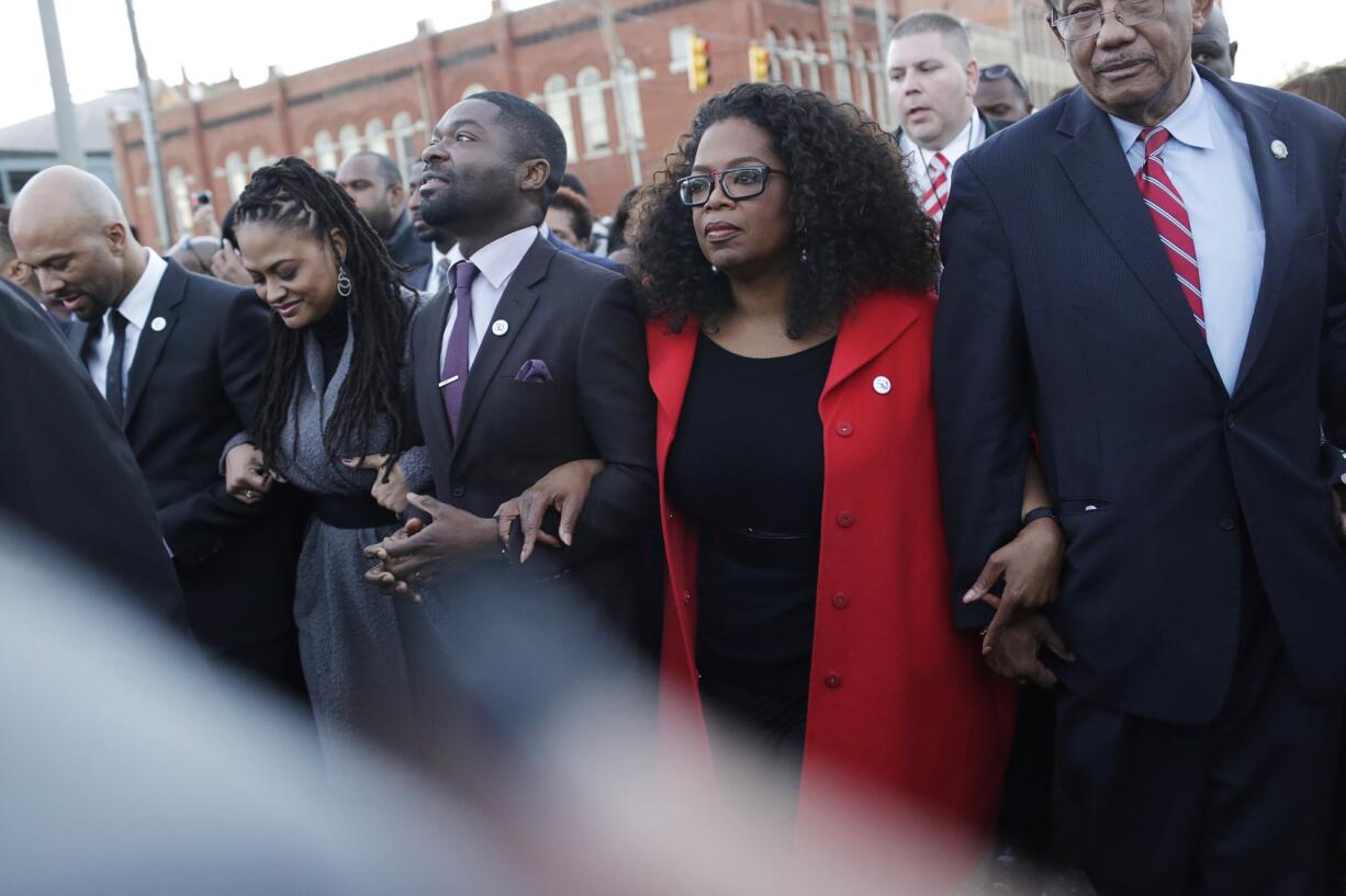 Oprah Winfrey locks arms Jan. 18 with David Oyelowo, left, who portrays Martin Luther King Jr.