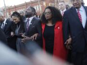 Oprah Winfrey locks arms Jan. 18 with David Oyelowo, left, who portrays Martin Luther King Jr.