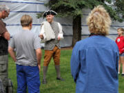 This photo taken July 8, 2014, shows Cameron Sanders with the National Park Service, center, at the start of a walking tour of Captain Cook sites from the Alaska Public Lands Information Center in downtown, Anchorage, Alaska. The center is a clearinghouse for state and federal land in the nation's largest state.