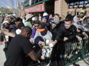 San Francisco Giants' Santiago Casilla signs autographs for fans after arriving for spring training baseball workouts in Scottsdale, Ariz.