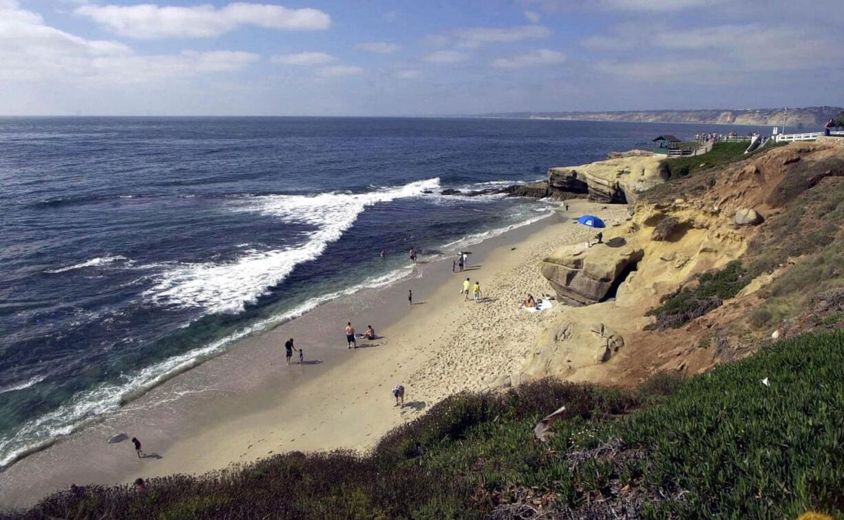 Associated Press files
People stroll down the beach in the La Jolla section of San Diego, Calif. With an average of 250 days of sunshine a year, any time is good to visit San Diego but summer means the chilly Pacific waters are warm enough for surfing without a wetsuit.