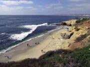 Associated Press files
People stroll down the beach in the La Jolla section of San Diego, Calif. With an average of 250 days of sunshine a year, any time is good to visit San Diego but summer means the chilly Pacific waters are warm enough for surfing without a wetsuit.