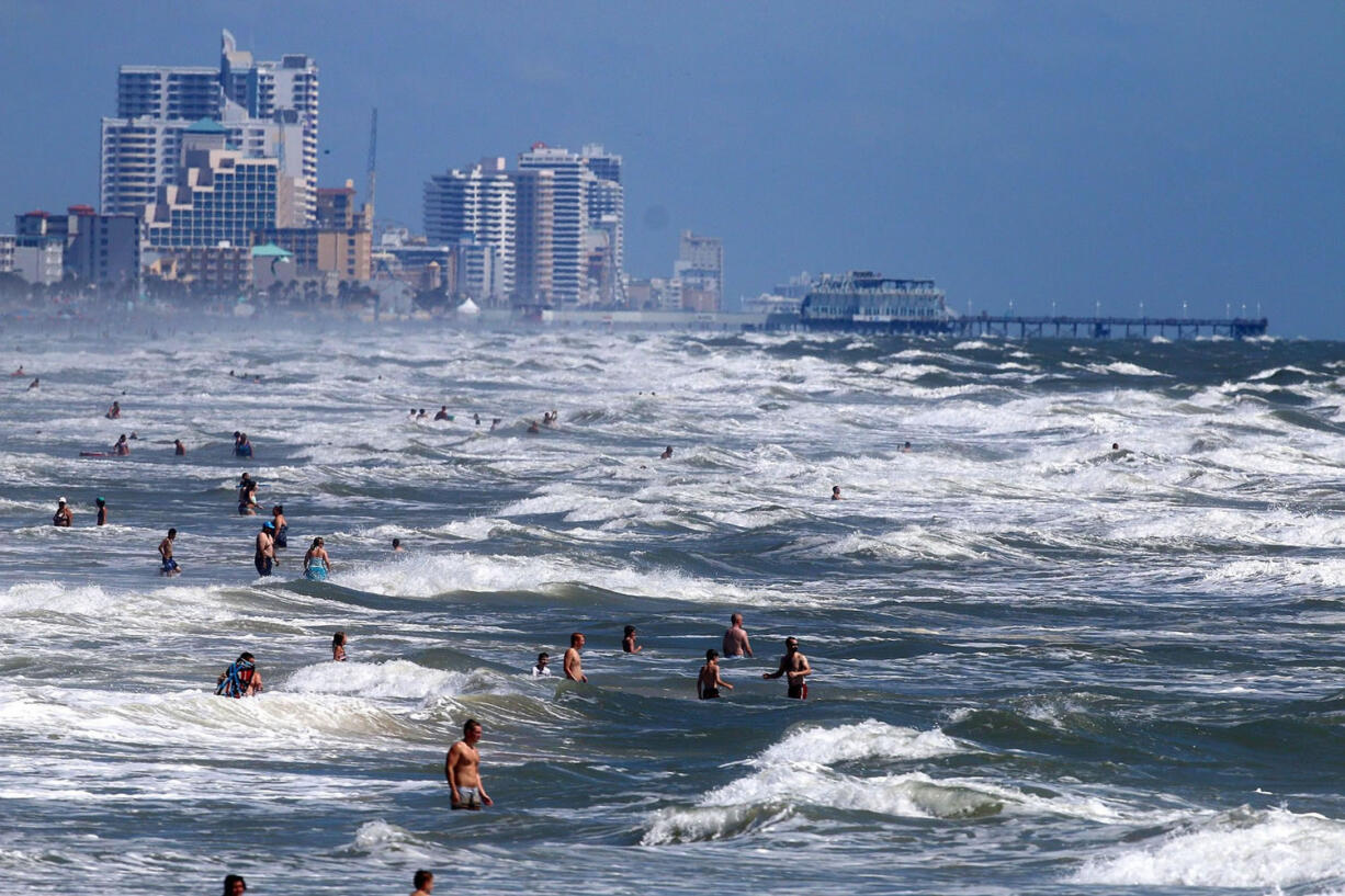 People deal with the high surf and currents off Daytona Beach generated by Tropical Storm Arthur on Tuesday.