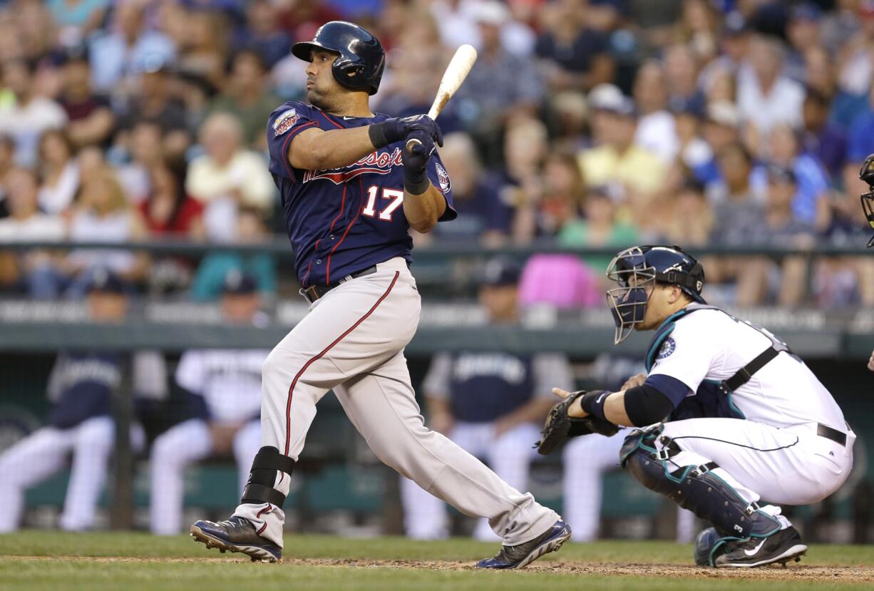 Minnesota Twins designated hitter Kendrys Morales (17) hits a two-run double in the fifth inning of a baseball game against the Seattle Mariners, Thursday, July 10, 2014, in Seattle. (AP Photo/Ted S.