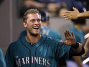 Seattle Mariners' Michael Saunders smiles as he is congratulated in the dugout on his home run against the Minnesota Twins in the seventh inning  Monday in Seattle.