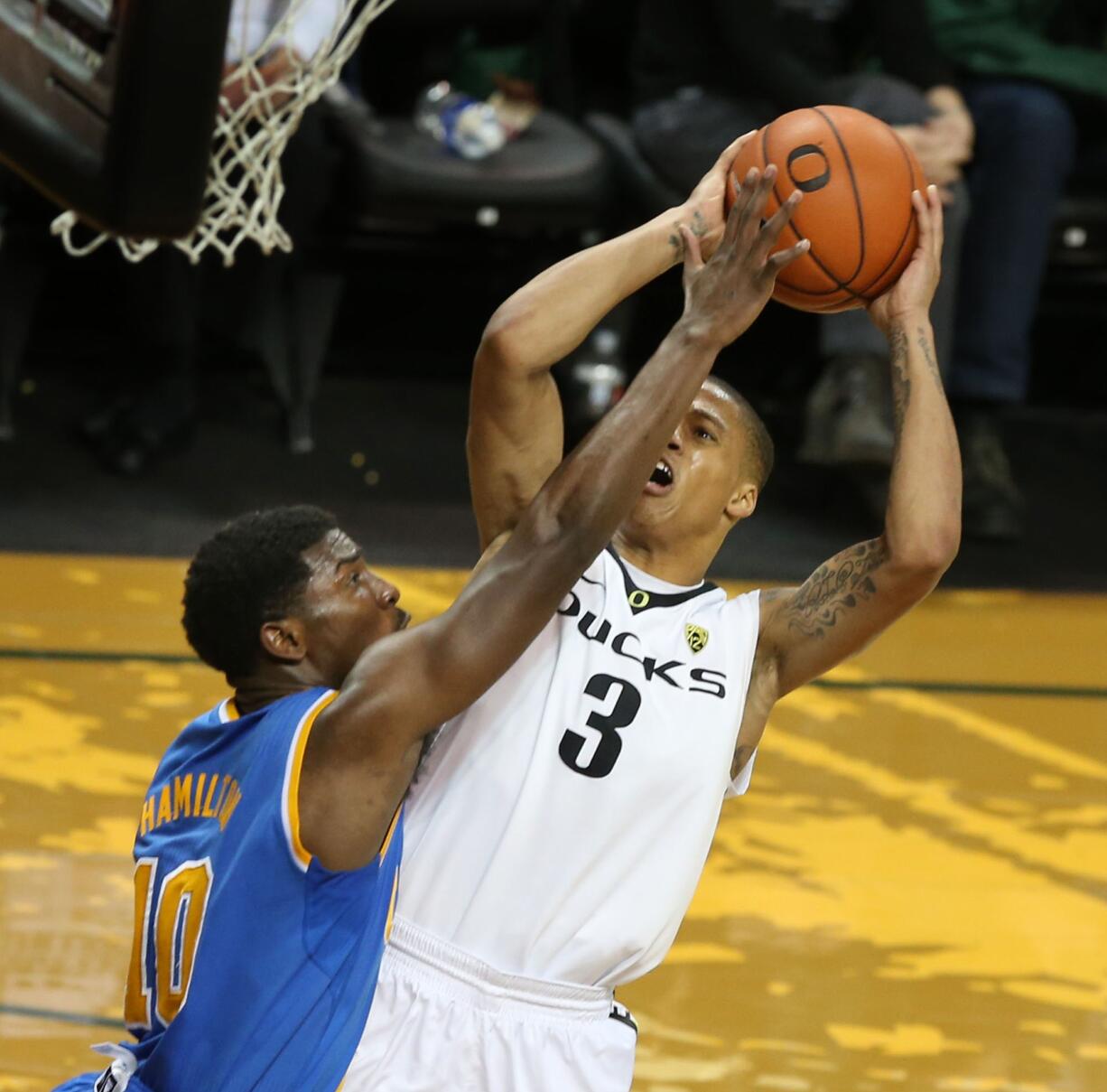 Oregon's Joseph Young, right, tries to shoot around UCLA's Isaac Hamilton during the second half Saturday, Jan. 24, 2015. Oregon won 82-64.