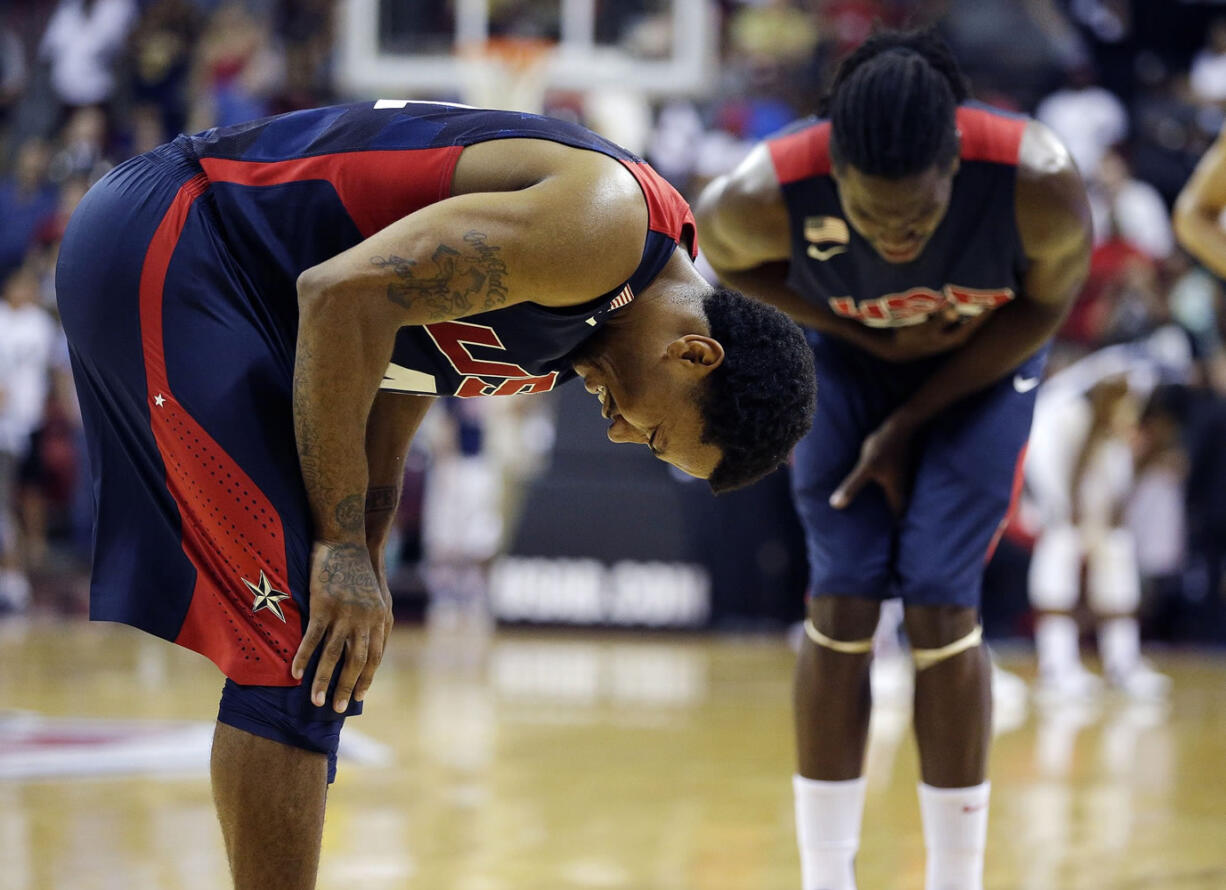 Chicago Bulls' Derrick Rose, left, and Denver Nuggets' Kenneth Faried, right, react after seeing Indiana Pacers' Paul George get injured during the USA Basketball Showcase game Friday, Aug. 1, 2014, in Las Vegas.