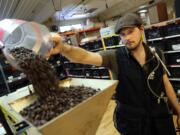 Just Coffee Cooperative's Benjamin Lisser prepares to grind coffee. The glass tube on his vest tests the air in his breathing zone for diacetyl and 2,3-pentanedione, two chemicals known to destroy lung capacity.