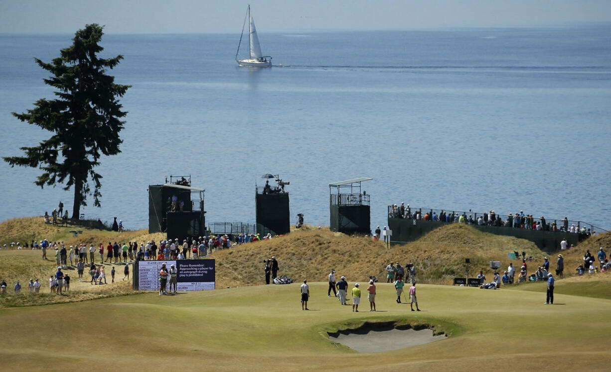 Ernie Els, of South Africa, far right, putts on the fifth hole during a practice round for the U.S.