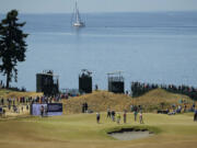 Ernie Els, of South Africa, far right, putts on the fifth hole during a practice round for the U.S.