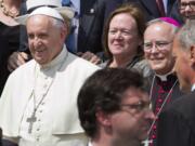 Philadelphia's Archbishop Charles Chaput, right, stands next to Pope Francis as they pose for a photo with a delegation from Philadelphia at the end of the pontiff's weekly general audience in St.