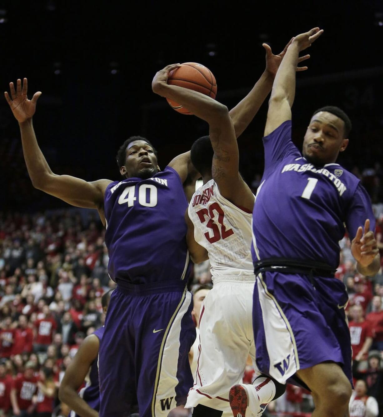 Washington State's Que Johnson (32) drives under the defense Washington's Shawn Kemp Jr. (40) and Darin Johnson during the first half Sunday, Feb. 22, 2015, in Pullman.