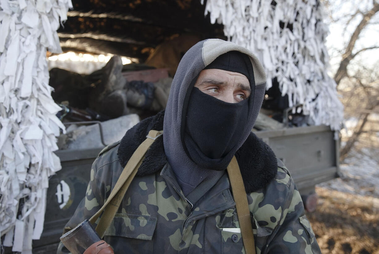 A Ukrainian serviceman stands next to a broken-down military vehicle Wednesday outside Artemivsk, Ukraine, while pulling out of Debaltseve.