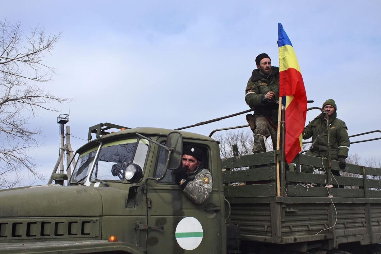 Pro-Russia rebels, one of them holding a flag of the rebel-held city of Luhansk, pose for a photo in Debaltseve, eastern Ukraine on Thursday.