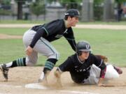 Union's Branden Whalen (7) makes it back to the bag before being tagged by Kentwood's first baseman Mike Ciancio in 4A state regional on Saturday, May 23, 2015, at Hiedelberg Park in Tacoma. Kentwood beat Union 17-6 to advance.