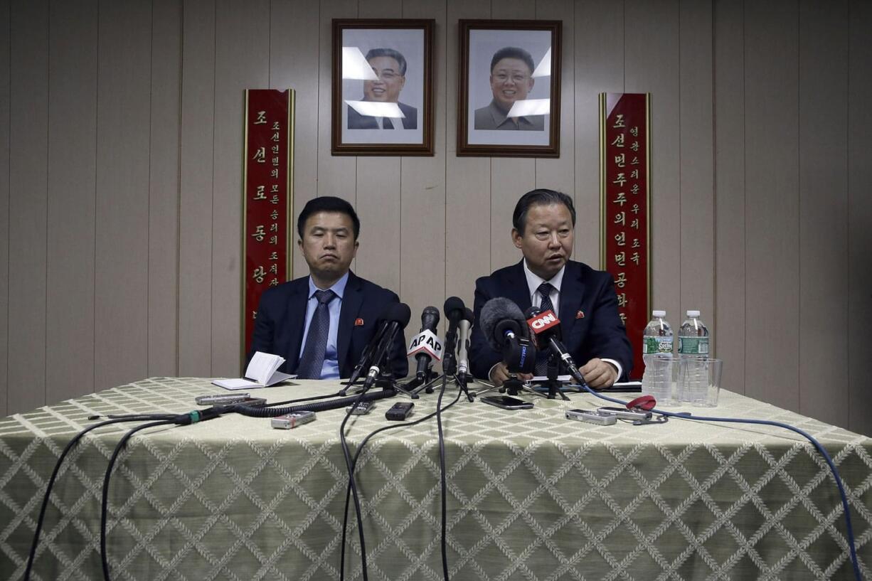 Under the portraits of the late North Korean leaders, Kim Il Sung, left, and Kim Jong Il, ambassador of the Permanent Mission of the Democratic People's Republic of Korea to the United Nations Jang Il Hun, right, is joined by councilor Kwon Jong Gun as he speaks during a new conference at the DPRK mission in New York.