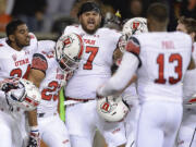 University of Utah running back Devontae Booker (23) celebrates with teammates after scoring a game winning touchdown in overtime against Oregon State on Thursday.