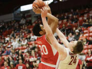 Utah forward Chris Reyes (20) puts up a shot over Washington State forward Josh Hawkinson (24) during the second half Thursday, March 5, 2015, in Pullman.