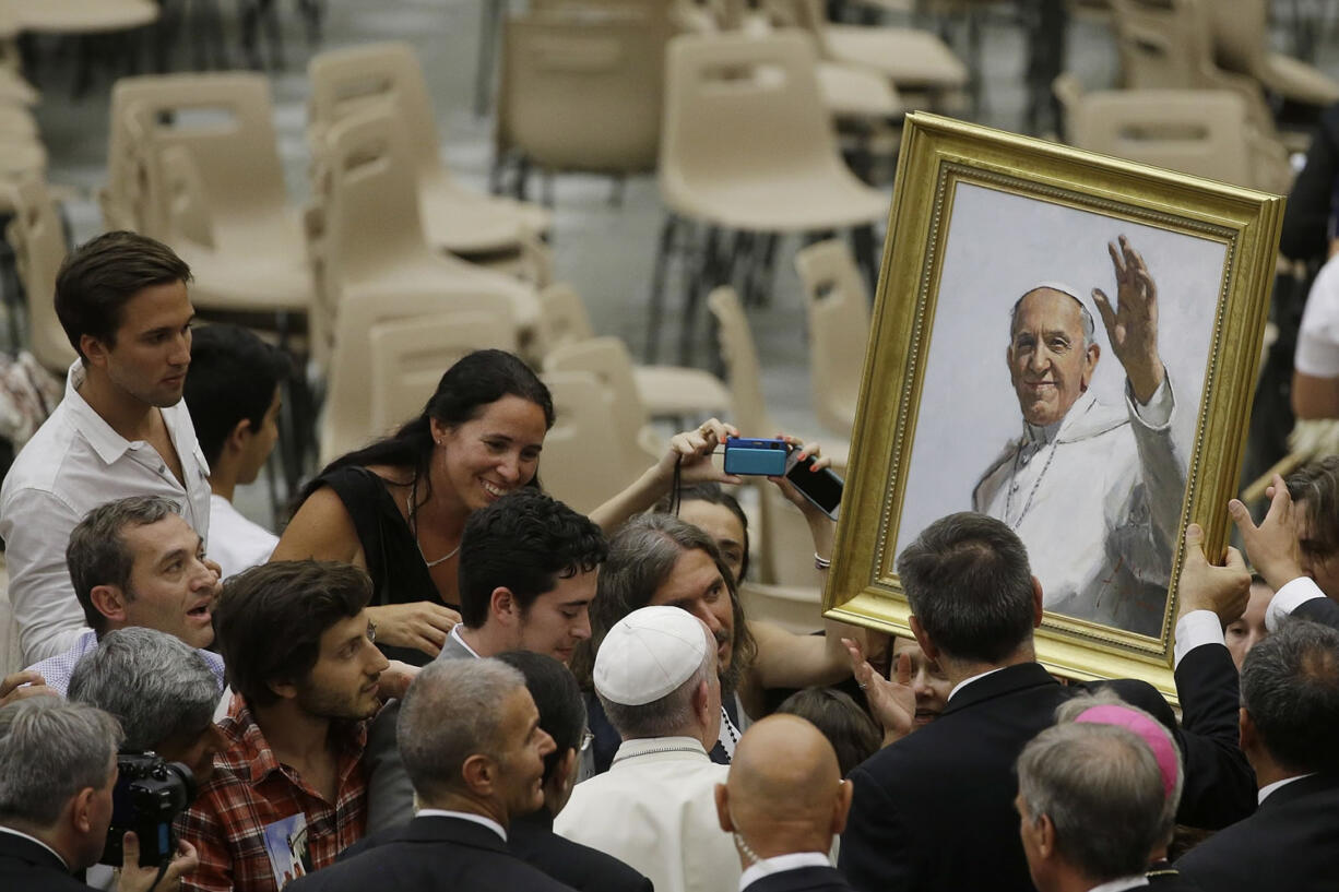 Pope Francis is presented with a portrait of the pontiff during the general audience in the Paul VI hall at the Vatican on Wednesday.