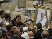 Pope Francis is presented with a portrait of the pontiff during the general audience in the Paul VI hall at the Vatican on Wednesday.