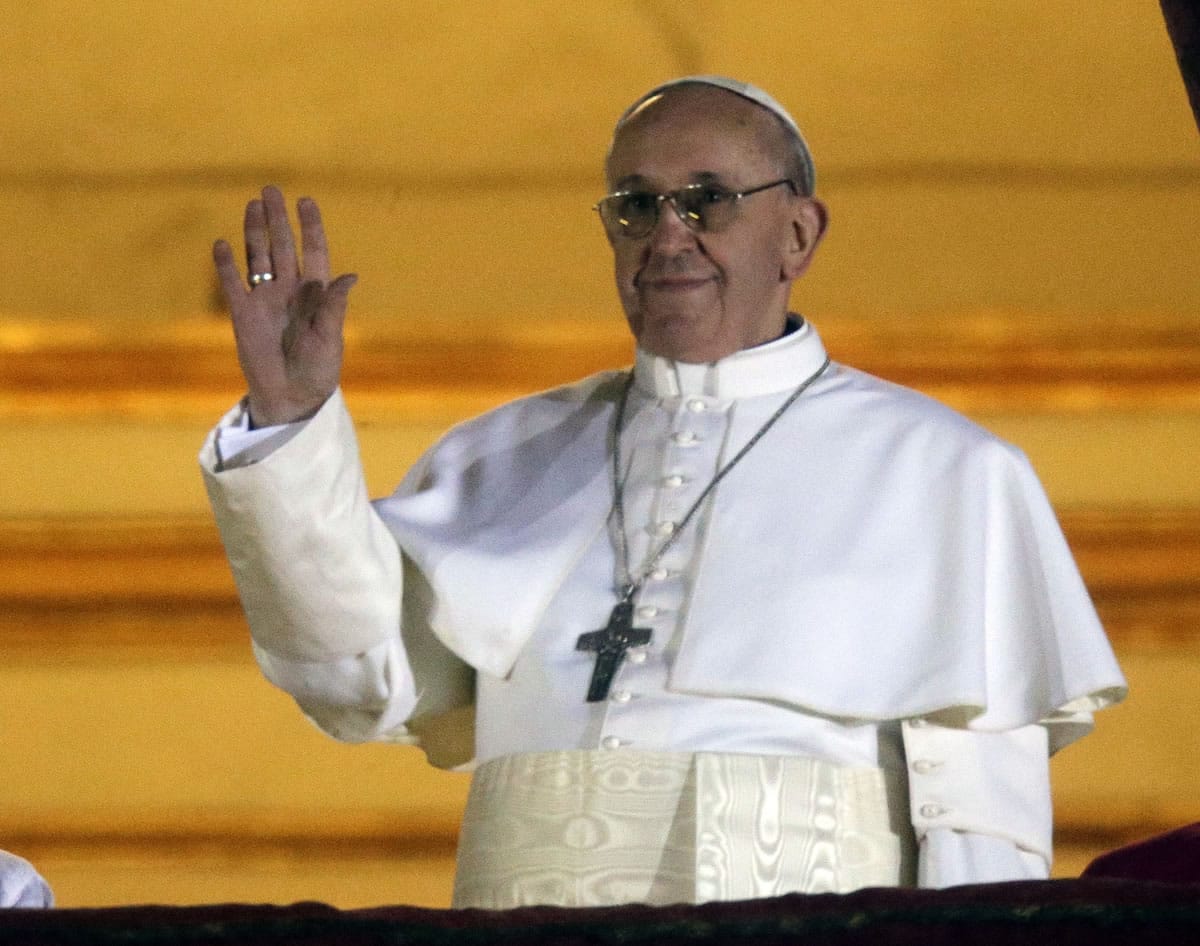 Pope Francis waves to the crowd from the central balcony of St.