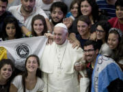 Pope Francis, flanked by pilgrims from Argentina, poses for pictures during his weekly general audience, in the Pope Paul VI hall, at the Vatican on Wednesday.