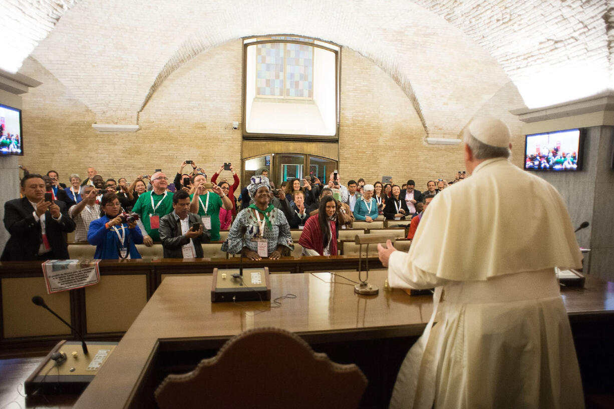 In this photo provided by the Vatican newspaper L'Osservatore Romano, Pope Francis meets with participants of the Global Meeting of Popular Movements, at the Vatican, Tuesday, Oct. 28, 2014.