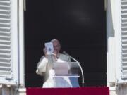 Pope Francis holds up a copy of the Gospel on Sunday during the Angelus prayer in St. Peter's Square at the Vatican.