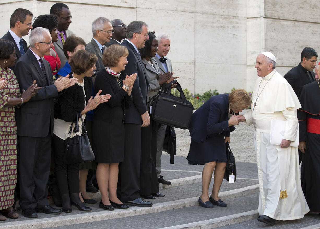 Pope Francis is greeted Friday by lay members as he arrives for an afternoon session of a two-week synod on family issues, at the Vatican. Gay rights groups are cautiously cheering a shift in tone from the Catholic Church toward homosexuals, encouraged that Pope Francis' famous &quot;Who am I to judge?&quot; position has filtered down to bishops debating family issues at a Vatican meeting this week.